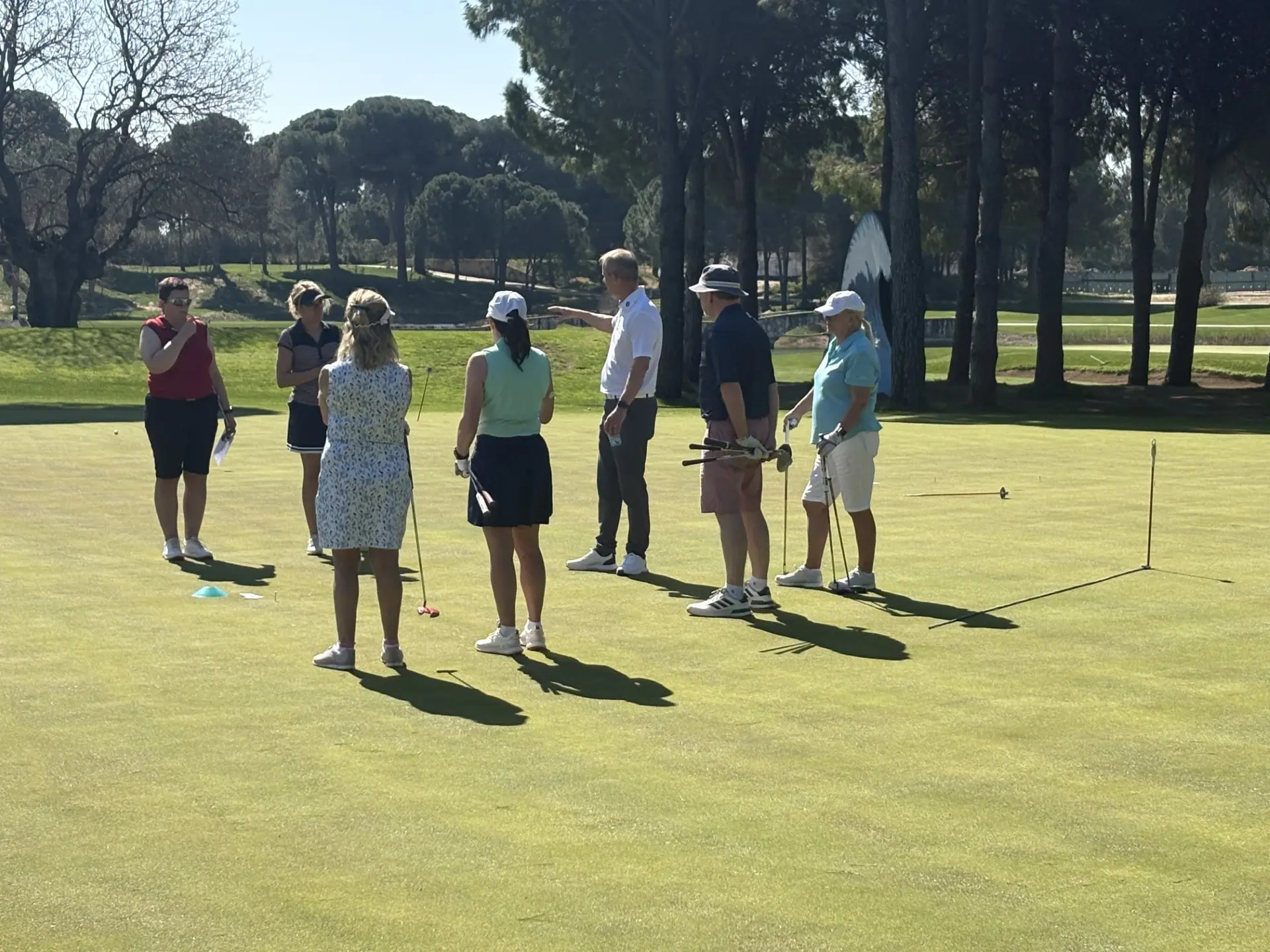 Warm weather golf school group coaching session on the practice green