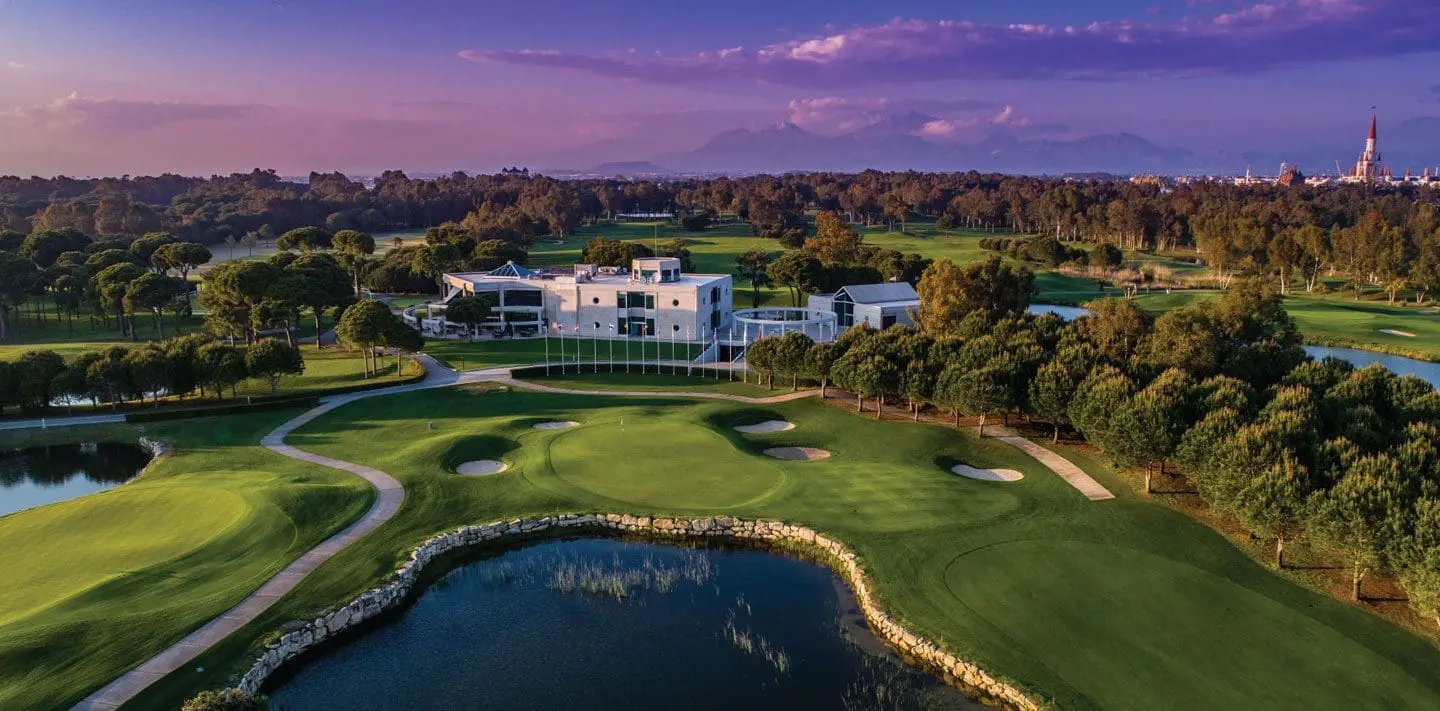 Aerial view of a golf course and clubhouse at dusk